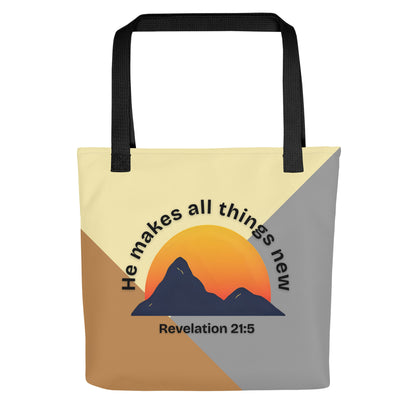 Front view of a color-block tote bag with black straps, featuring a mountain-and-sun graphic and the text “He makes all things new” with “Revelation 21:5” underneath.