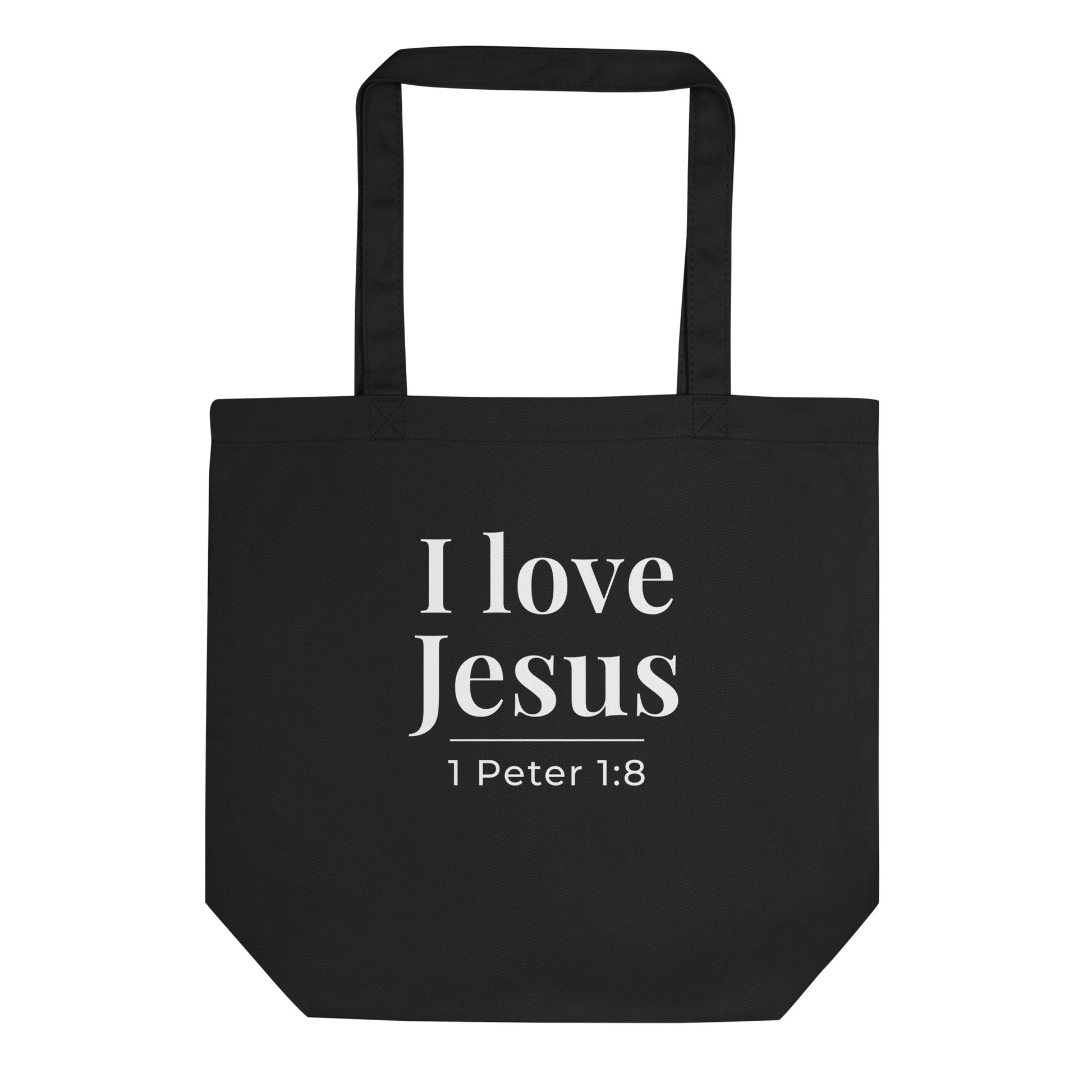 Black cotton tote bag with “I love Jesus” in white text and “1 Peter 1:8” underneath.