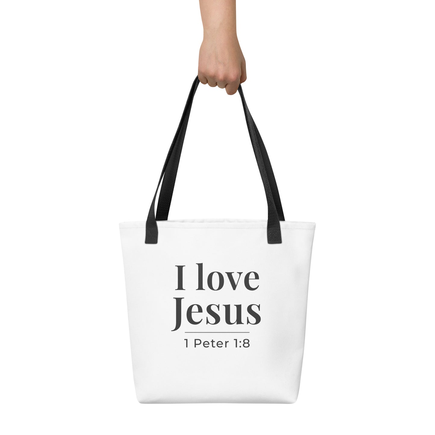 White tote bag held in hand featuring “I love Jesus” in dark gray text with “1 Peter 1:8” underneath.