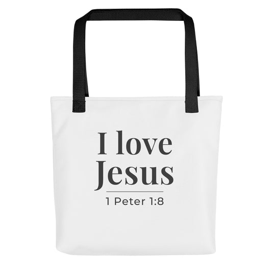 White tote bag with black handles featuring the phrase “I love Jesus” and “1 Peter 1:8” in dark gray text.