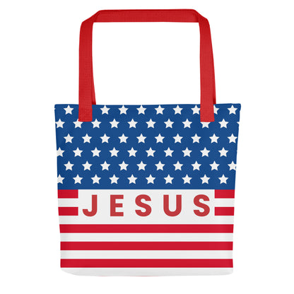 Front view of a patriotic Christian tote bag with red handles, blue stars, red and white stripes, and “Jesus” text across the center.