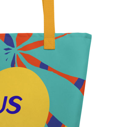 Close-up of the tote’s upper corner showing a mustard-yellow woven strap stitched to the top edge, with a teal background and orange-and-navy leaf/palm shapes; the edge of a large yellow heart and part of the blue “JESUS” lettering are visible at the lower left.
