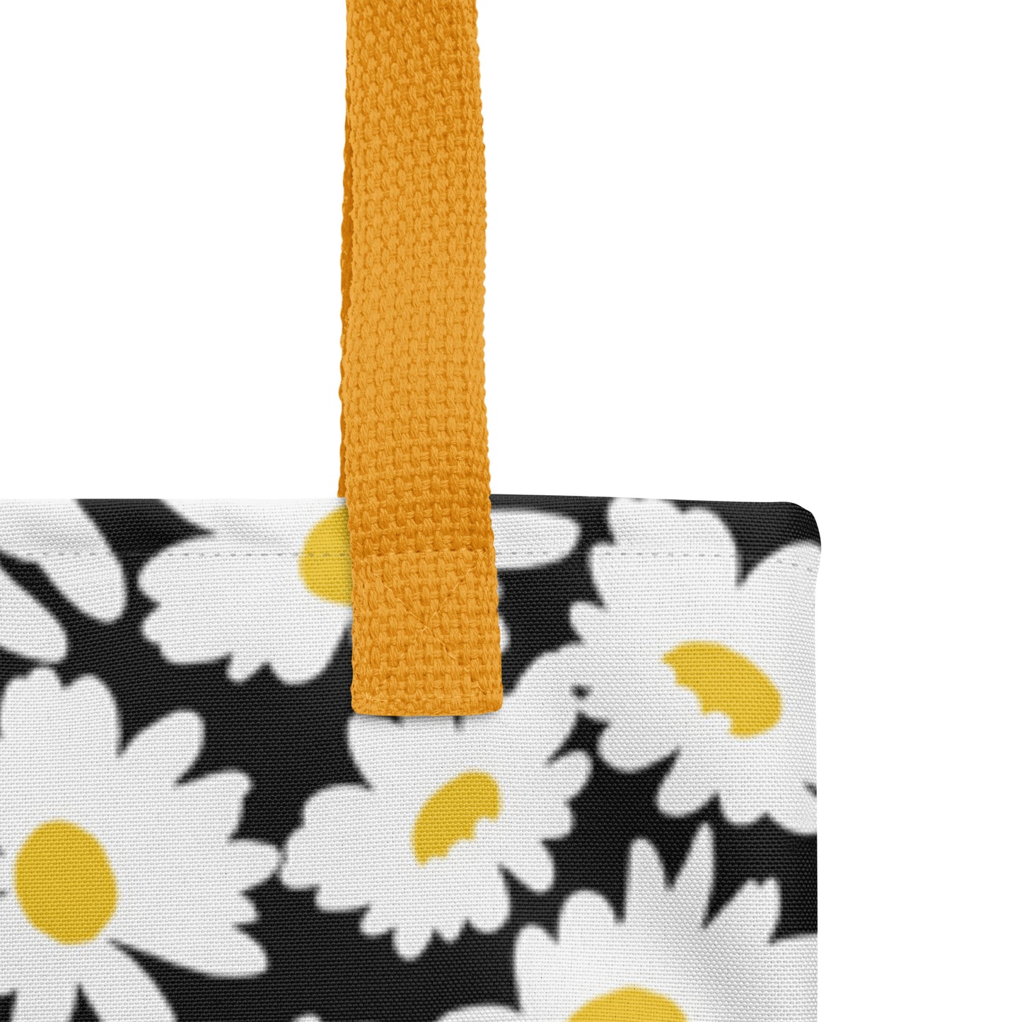 Close-up of the black daisy-print tote fabric and mustard yellow strap, highlighting the stitching, textured canvas, and floral pattern detail.
