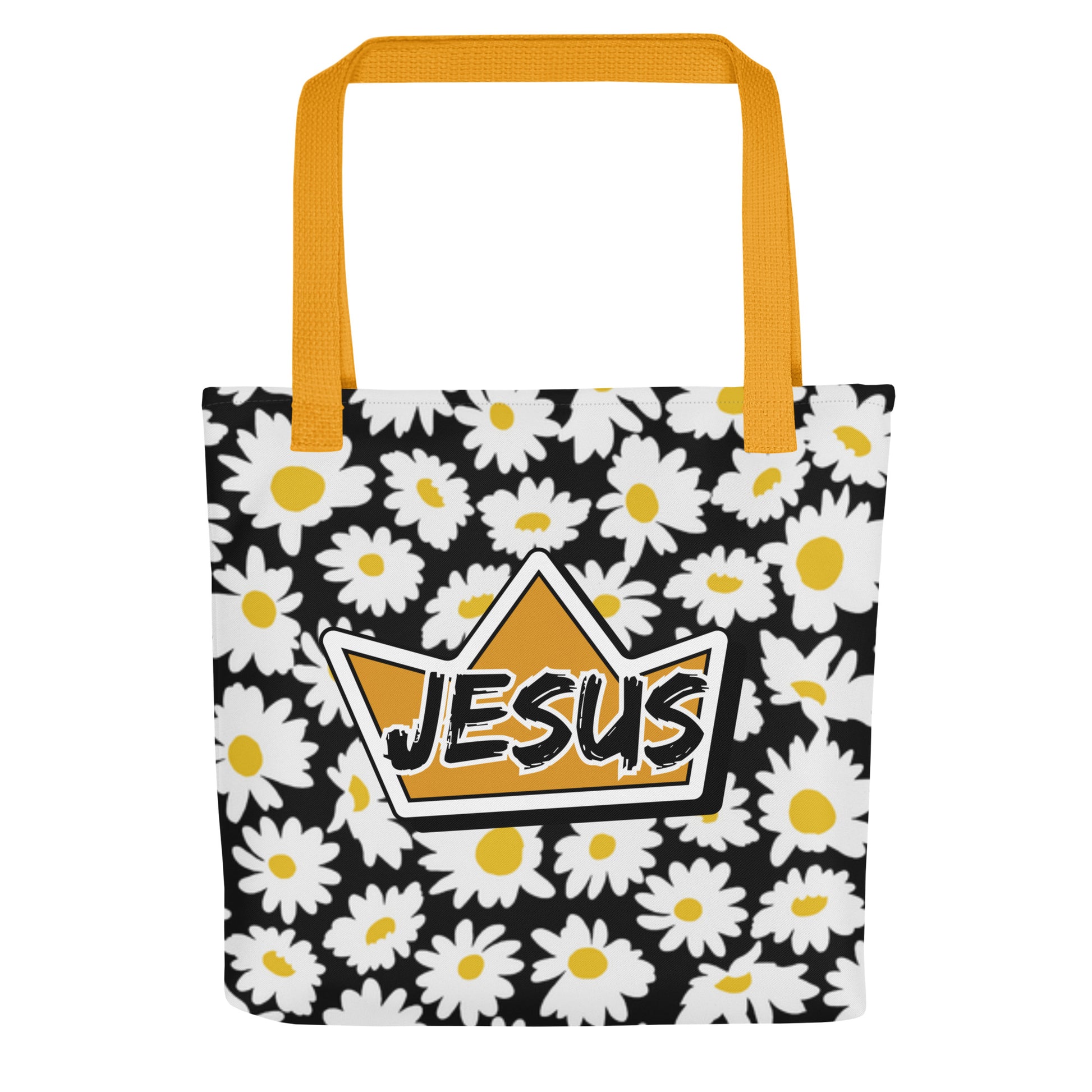 Front view of a black daisy-print tote bag with mustard yellow straps, featuring a gold crown graphic with the word “JESUS” in bold lettering on the front.