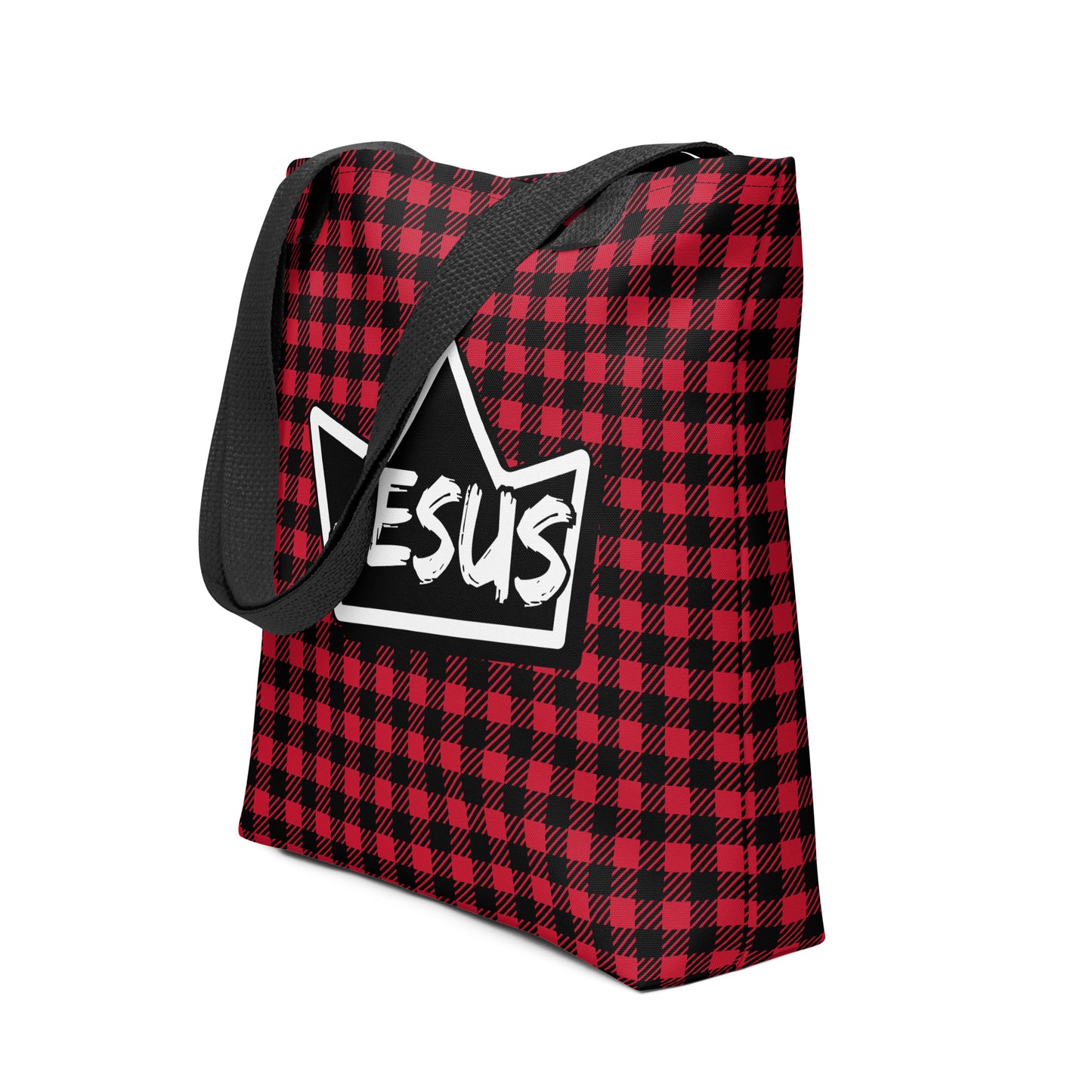 Angled view of the red-and-black plaid tote with black handles, showing the crown-shaped “JESUS” design centered on the front.