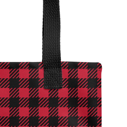 Close-up of the red and black plaid tote fabric and black strap, highlighting the stitching, textured canvas, and buffalo check pattern.