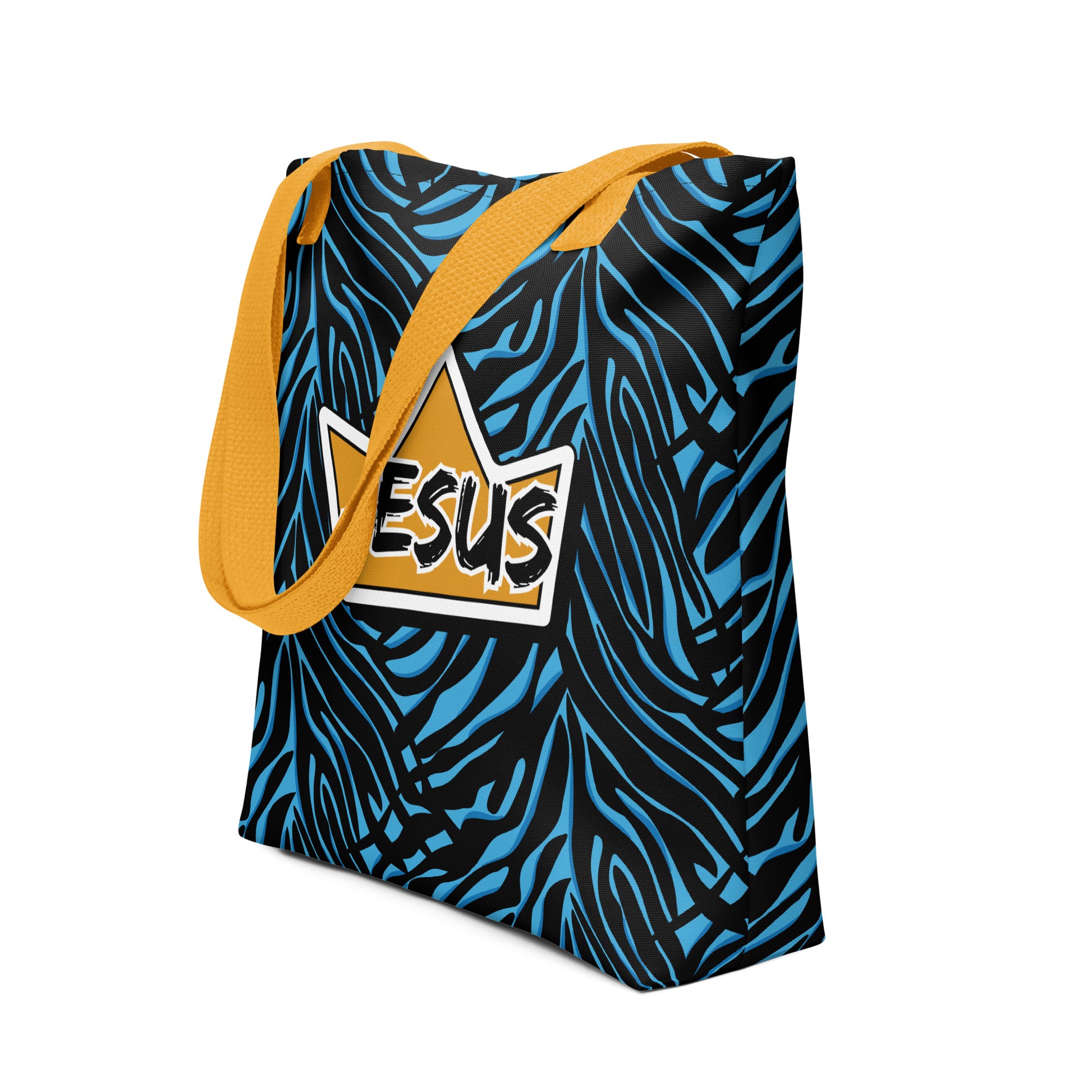 Angled view of a patterned tote bag with yellow straps, showing the blue-and-black zebra print and central crown “JESUS” design.