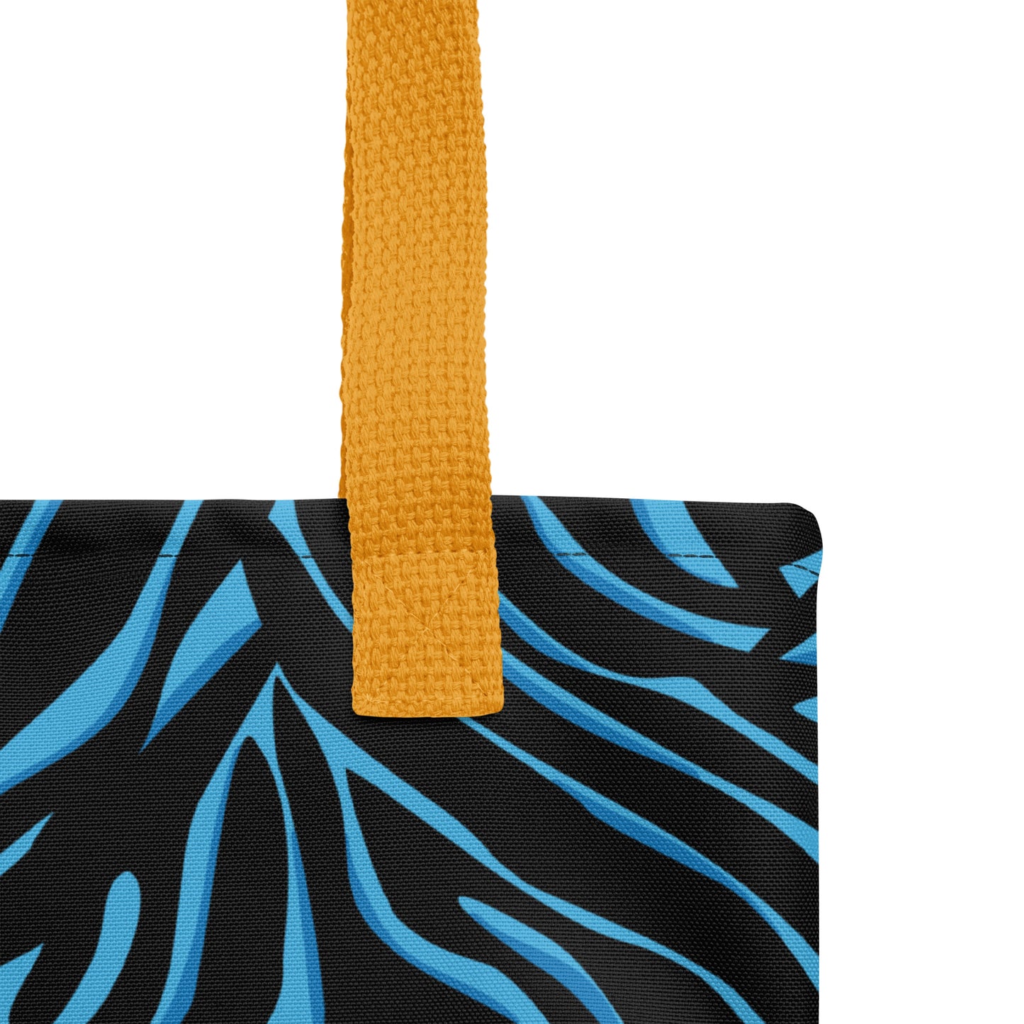 Close-up of the black-and-blue zebra print tote fabric and mustard yellow strap, highlighting the stitching, textured canvas, and bold pattern detail.