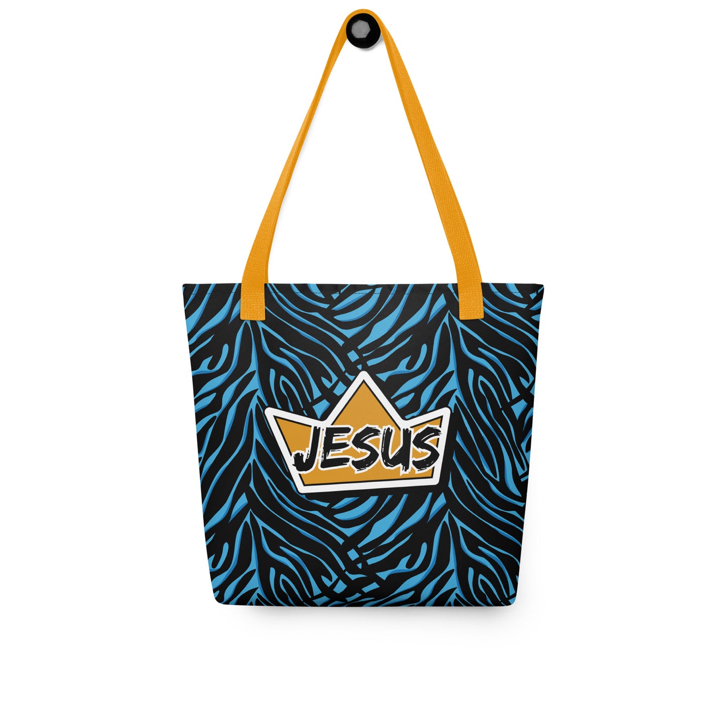 Tote bag hanging on a hook with yellow handles, a blue-and-black zebra pattern, and a crown “JESUS” graphic on the front.