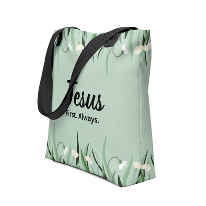 Angled view of the mint green tote with black handles, showing the floral border design and “Jesus. First. Always.” text.