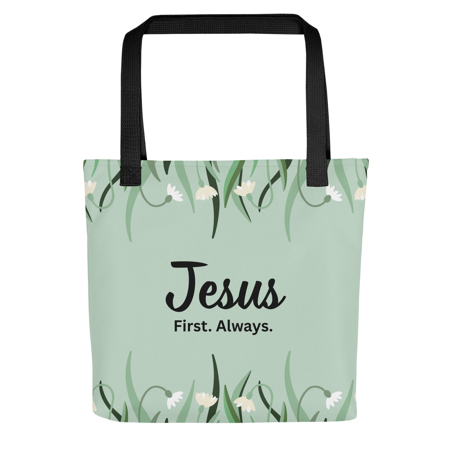 Front view of a mint green floral tote bag with black straps featuring the phrase “Jesus. First. Always.” in black lettering.
