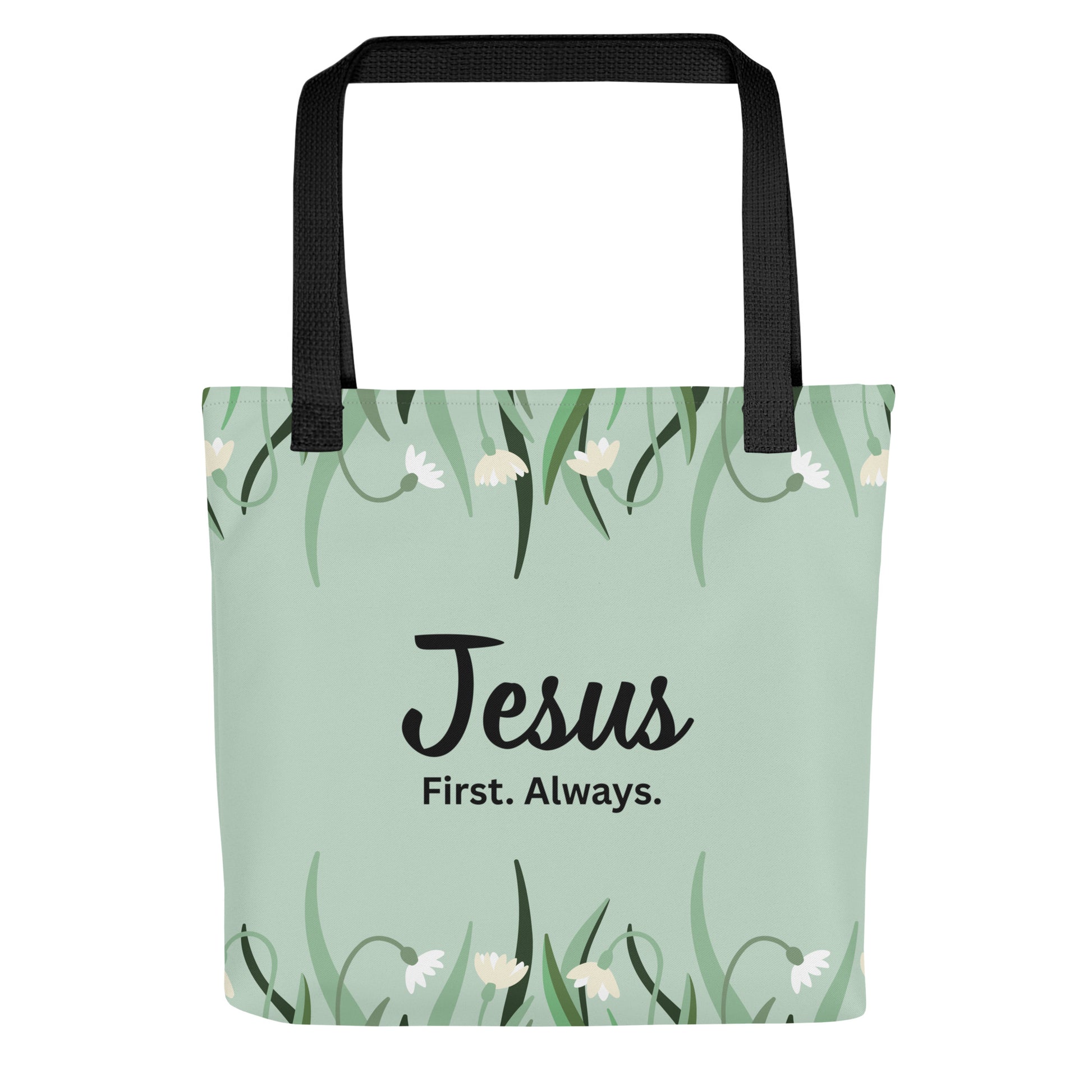 Front view of a mint green floral tote bag with black straps featuring the phrase “Jesus. First. Always.” in black lettering.