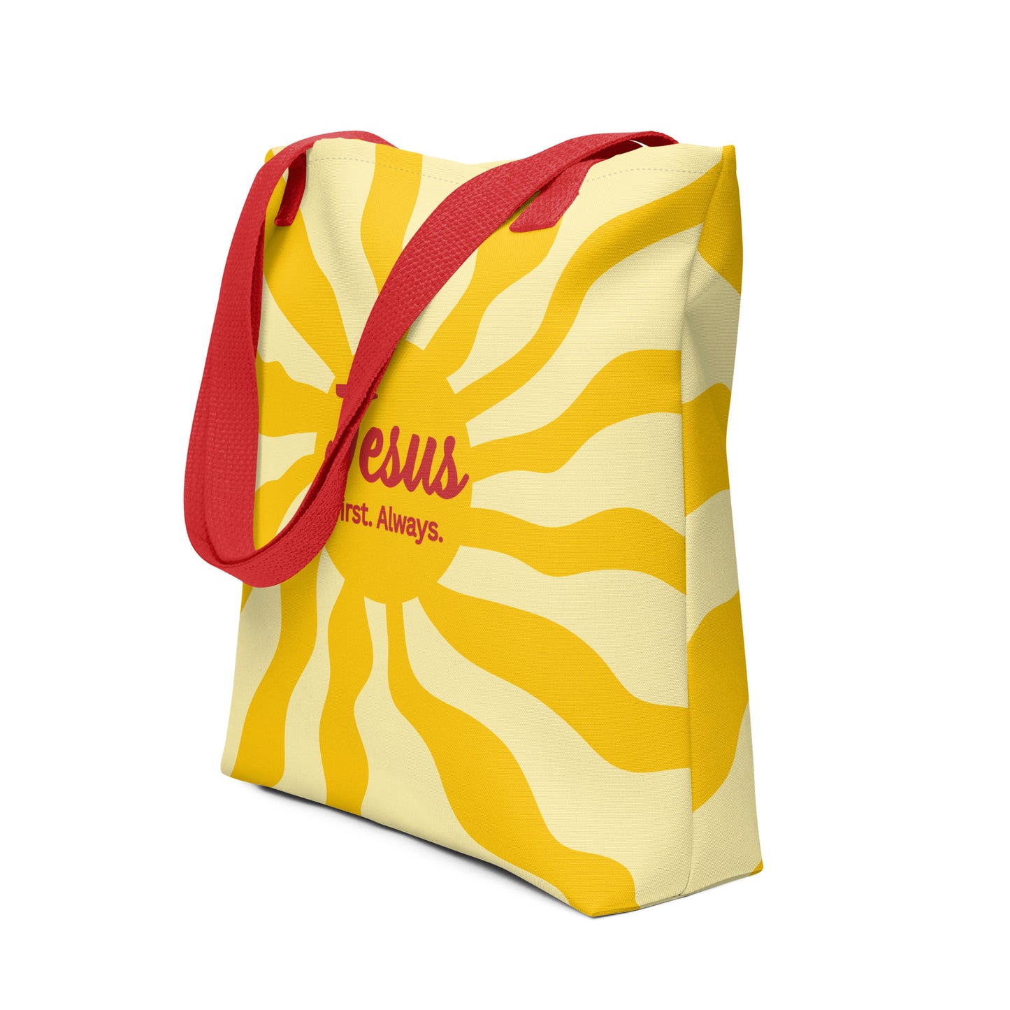 Angled view of red-strap tote bag showing yellow sunburst pattern and “Jesus First. Always.” design on the front.