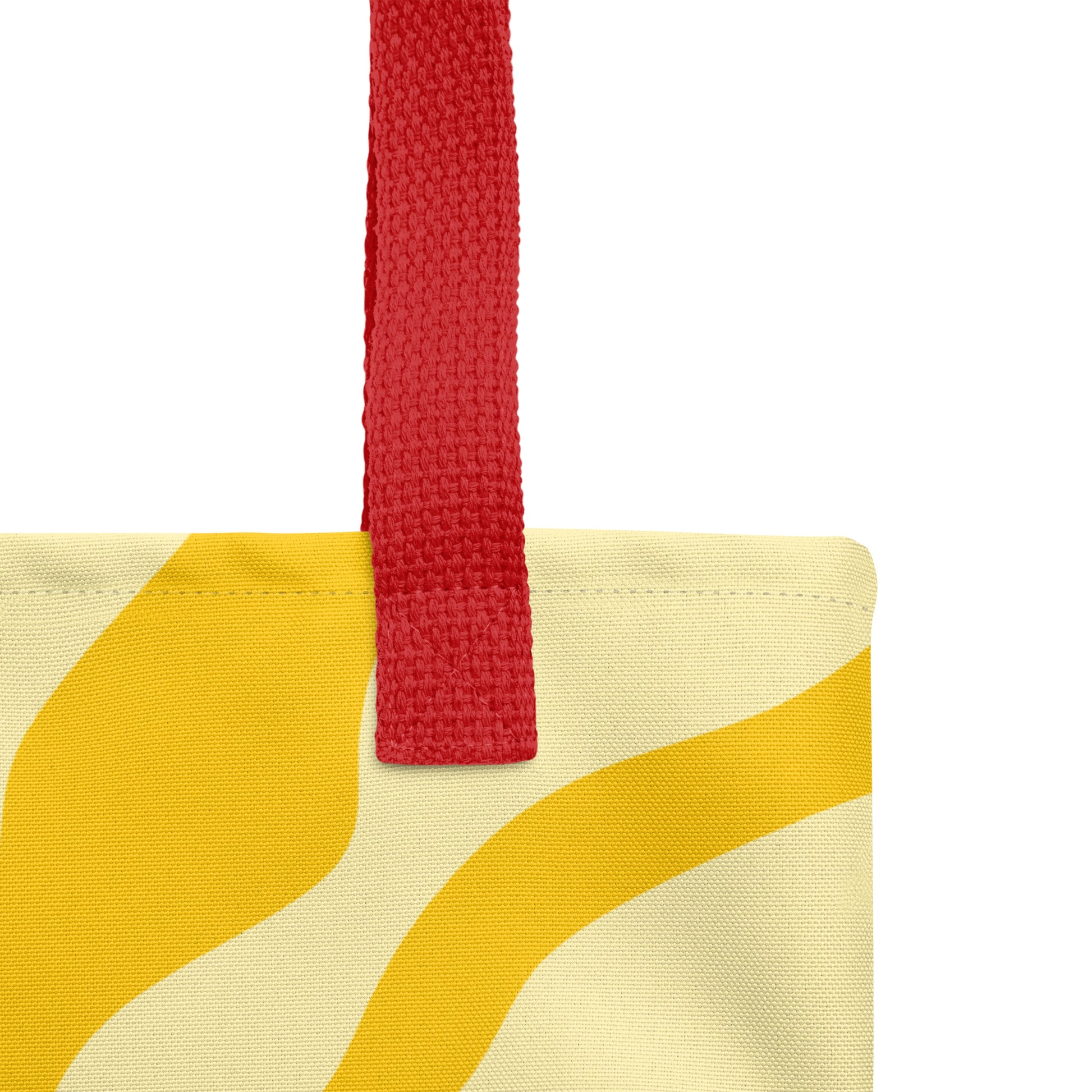 Close-up of red handle stitching and textured fabric with yellow sunburst pattern on the tote bag.