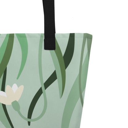 Close-up of black woven handle and stitched top edge on the sage green fabric with leafy floral print.