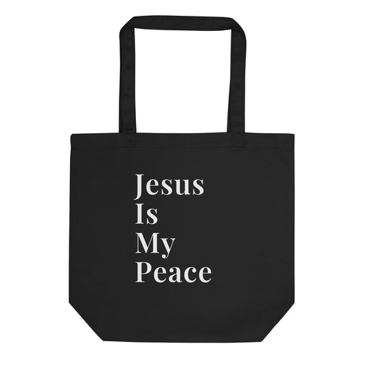 Black cotton tote bag with white stacked text reading “Jesus Is My Peace” on the front.