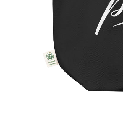 Close-up of a black cotton Christian tote bag showing the fabric texture, certified organic side tag, and part of the white “Jesus Is My Peace” design.