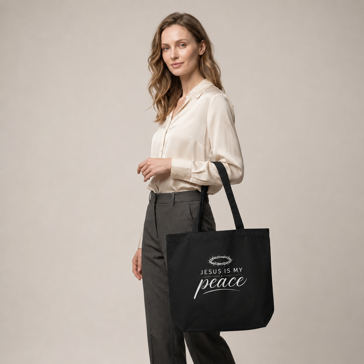 Model carrying a black cotton Christian tote bag with a white “Jesus Is My Peace” faith-based design.