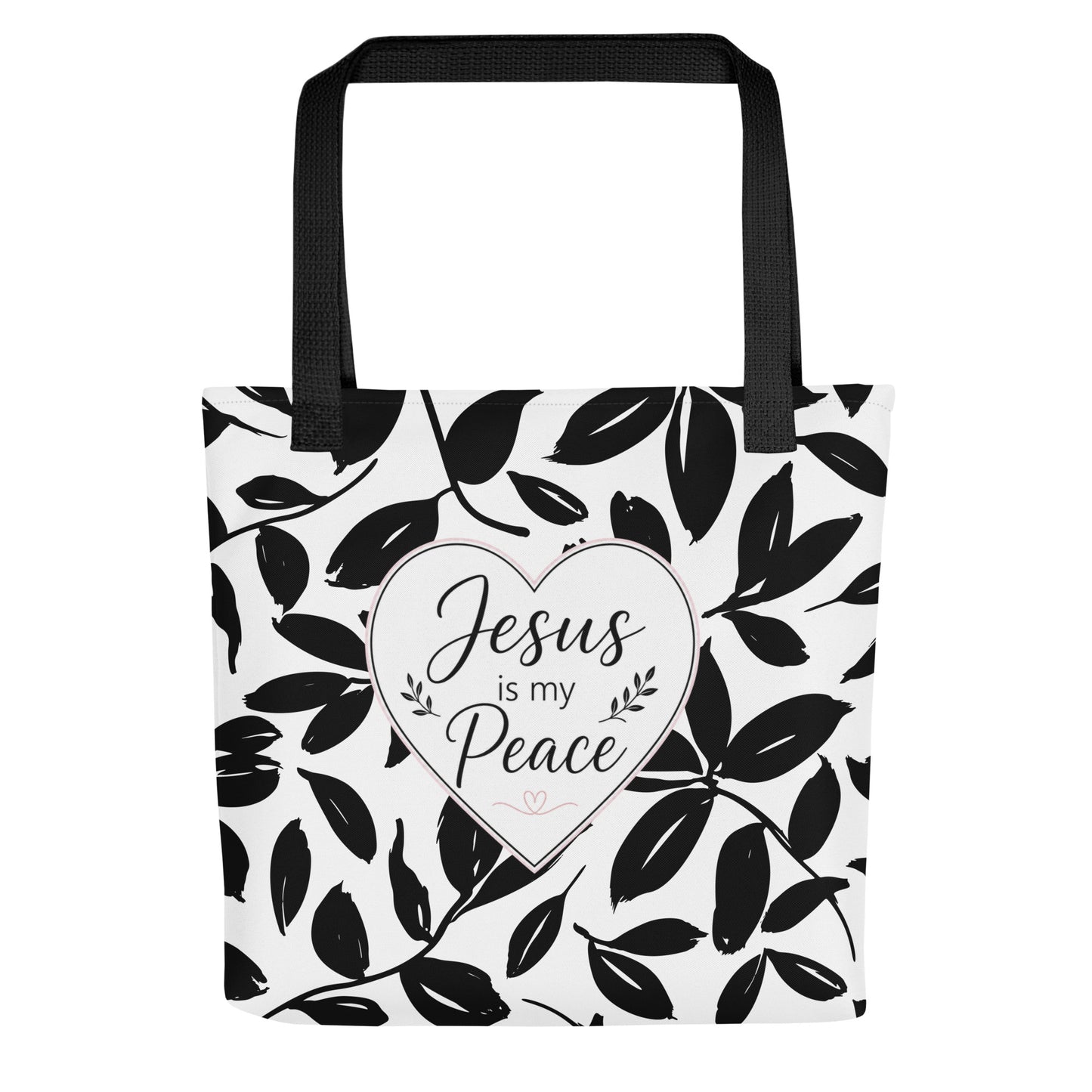 Front view of a black and white Christian tote bag with black handles, leafy pattern, and a heart design that says “Jesus is my Peace.”