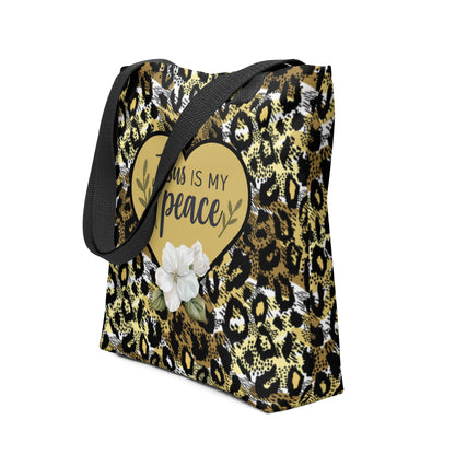 Angled view of the “Jesus is my peace” tote featuring black straps, gold-and-black cheetah pattern, gold heart graphic, and white flower detail.