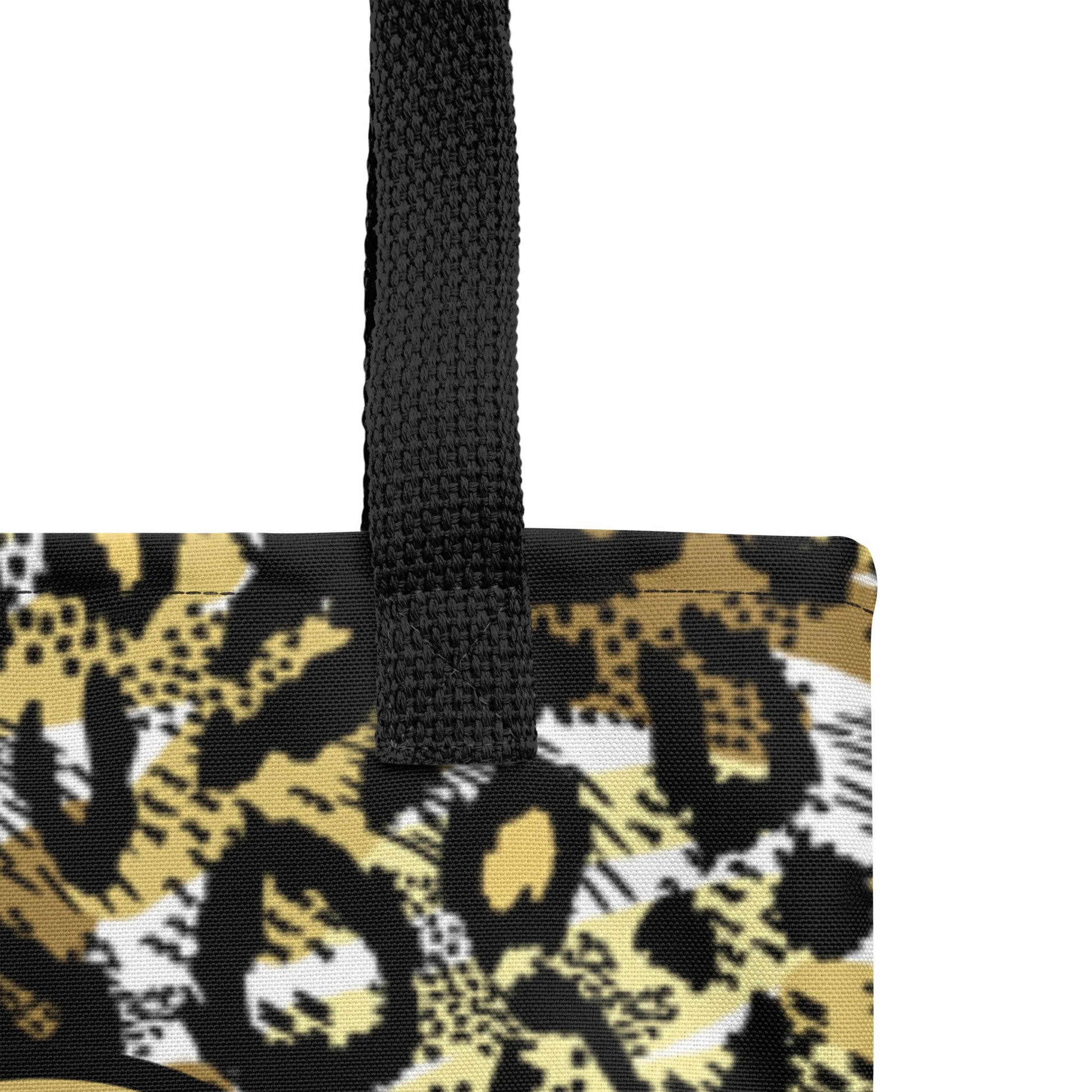 Close-up of the tote’s textured fabric and black woven handle, showing the gold-and-black cheetah print pattern near the top seam.