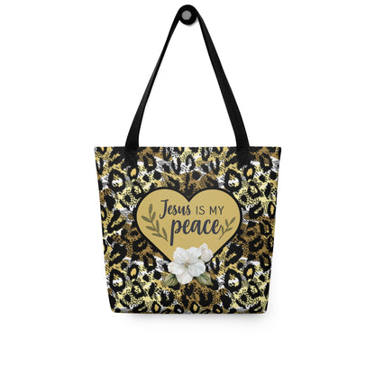 “Jesus is my peace” cheetah print tote hanging on a hook, showing black handles, gold heart design, and white flower on the front.