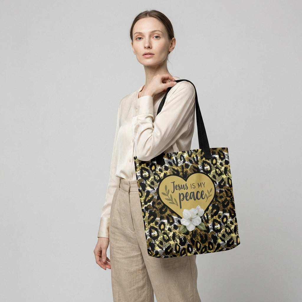 Lifestyle photo of a model carrying the “Jesus is my peace” cheetah print tote with black straps, featuring a gold heart and white flower graphic.