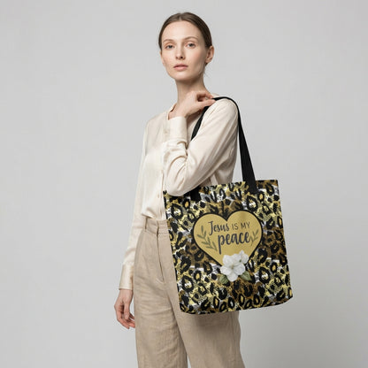 Lifestyle photo of a model carrying the “Jesus is my peace” cheetah print tote with black straps, featuring a gold heart and white flower graphic.