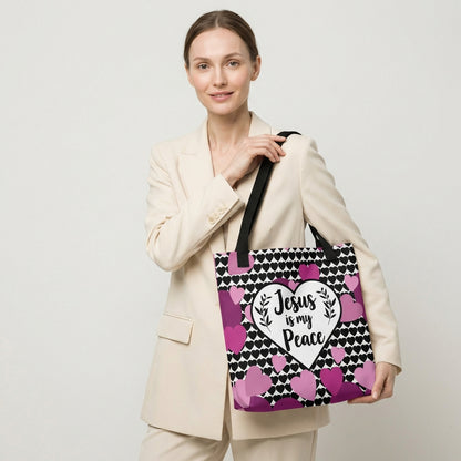 Model carrying a heart-print tote with black straps, featuring the “Jesus is my Peace” design in a white heart with pink and purple hearts.