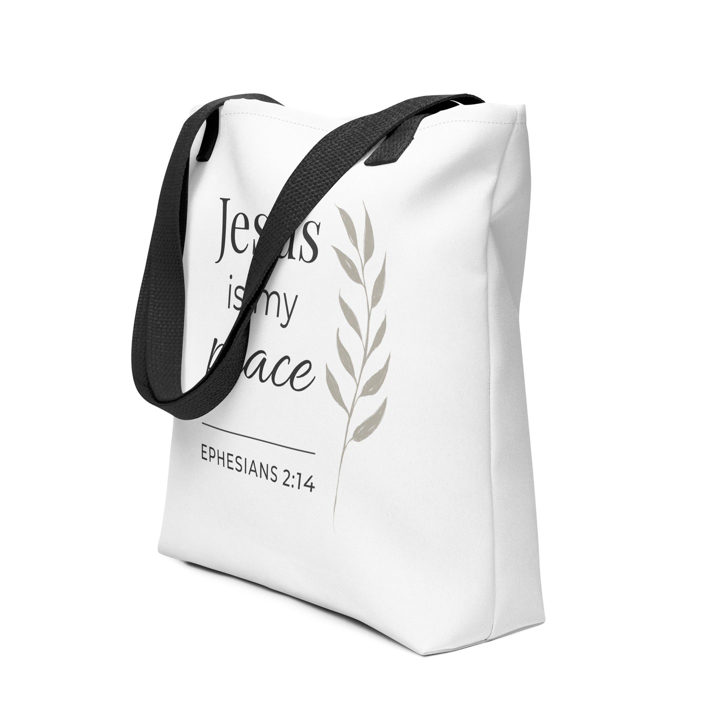 Angled view of a white tote bag with black handles featuring “Jesus is my peace,” “Ephesians 2:14,” and a leaf design in dark gray.