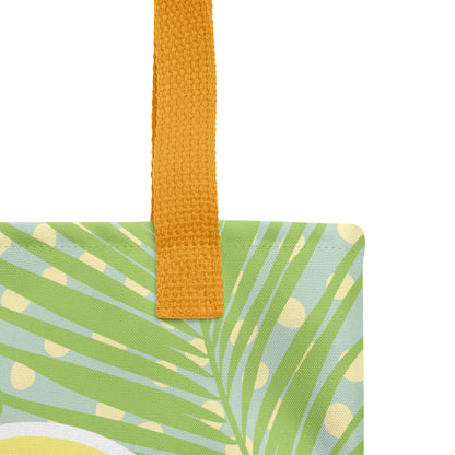 Close-up of the tote bag’s woven mustard-yellow handle and textured fabric with green palm fronds and cream polka dots.