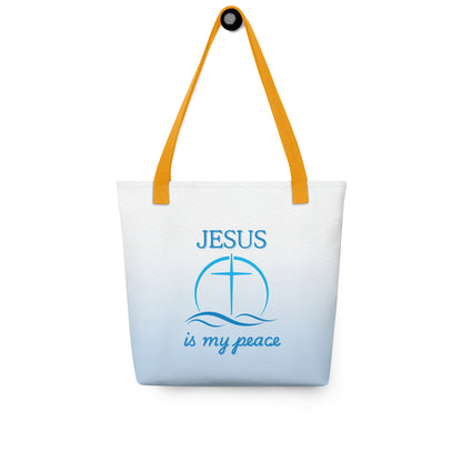 Tote bag hanging on a hook, featuring yellow handles, a light blue wave print, and “JESUS is my peace” with cross design.