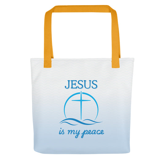 Front view of white tote bag with yellow handles, blue wave pattern, and “JESUS is my peace” text with a cross over waves.