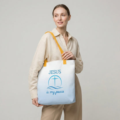 Lifestyle photo of a person carrying the white tote with yellow handles, blue wave pattern, and “JESUS is my peace” cross graphic.
