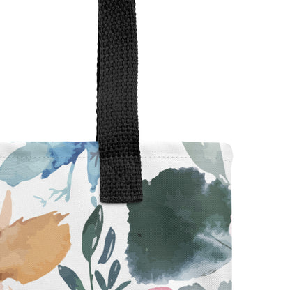 Close-up of a floral Christian tote bag showing the black woven handle, fabric texture, and watercolor flower and leaf pattern.