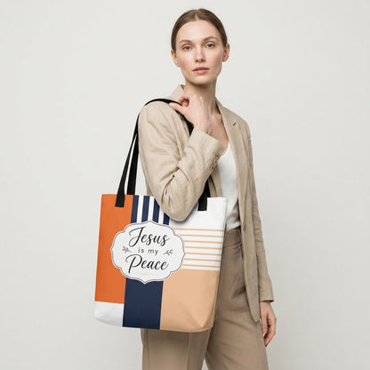 Model carrying a modern Christian tote bag with black handles, geometric color-block artwork, and “Jesus is my Peace” lettering.