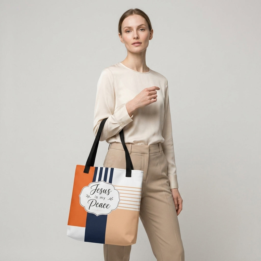 Model carrying a modern Christian tote bag with black handles, geometric color-block artwork, and “Jesus is my Peace” lettering.