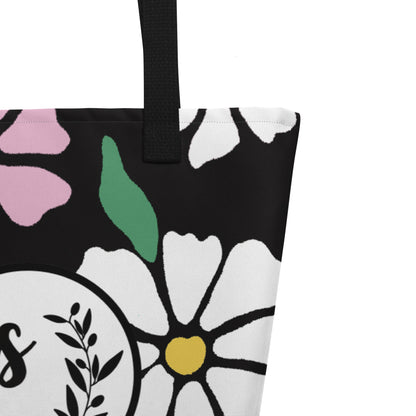 Close-up of black woven handle and stitched top edge on the black fabric with colorful floral print.