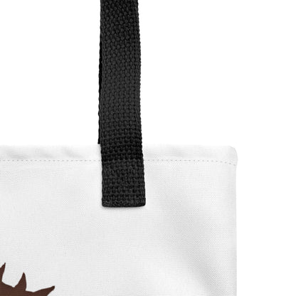 Close-up of the white tote fabric and black strap, highlighting the stitching, textured canvas, and strap weave detail.