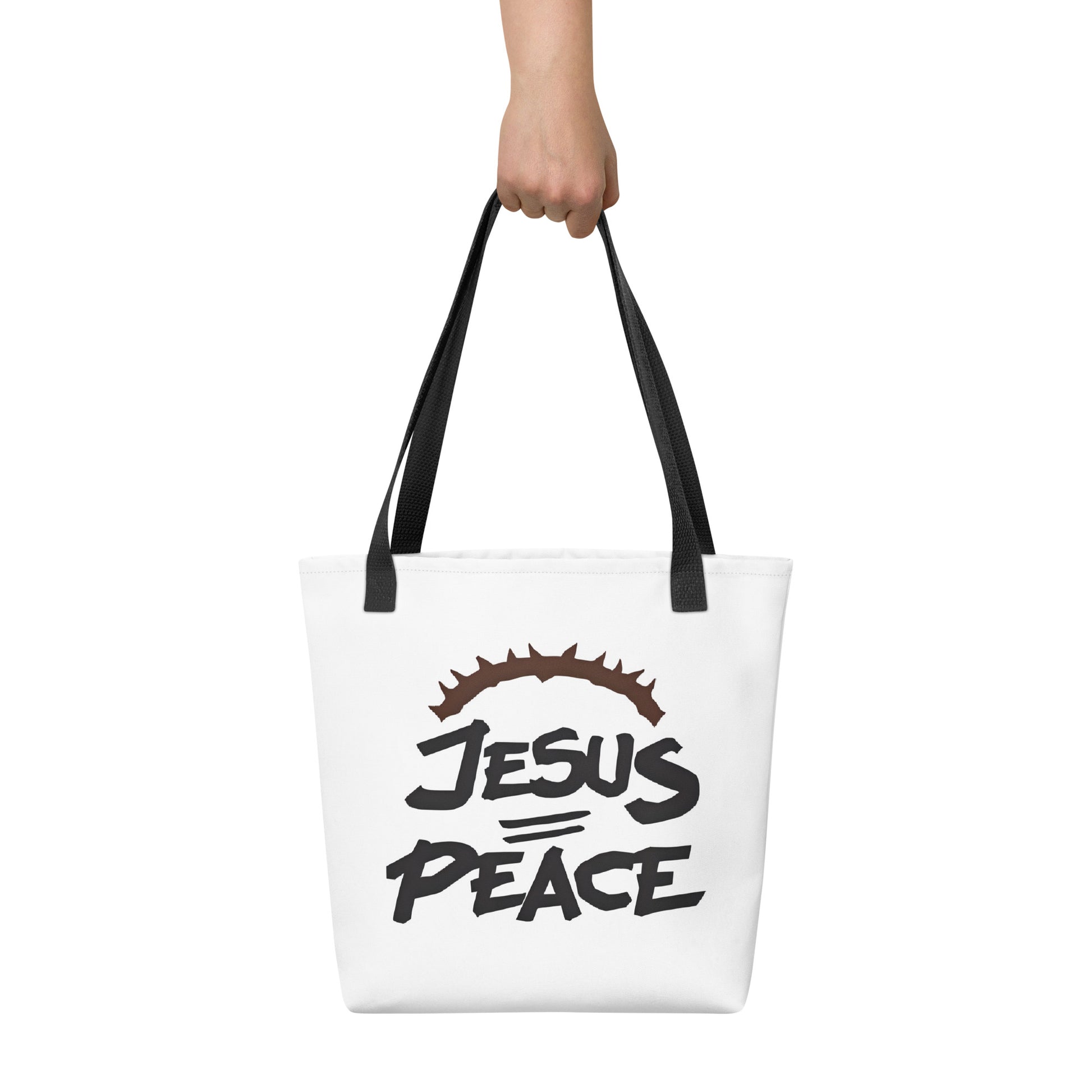 Tote bag carried by hand with black handles, showing the bold “JESUS PEACE” lettering and crown of thorns.
