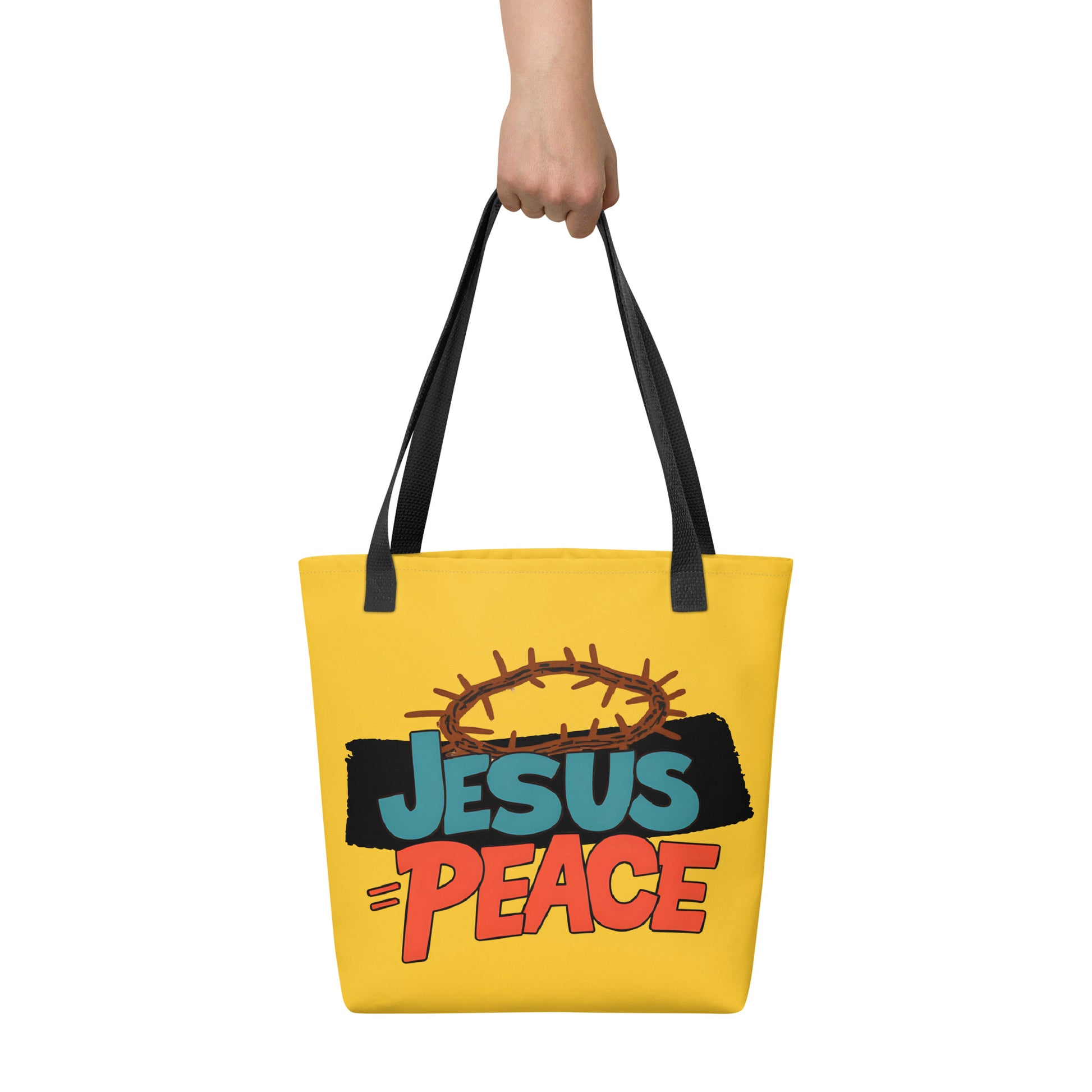 Hand holding yellow tote bag with black handles and “JESUS = PEACE” graphic with a crown of thorns.
