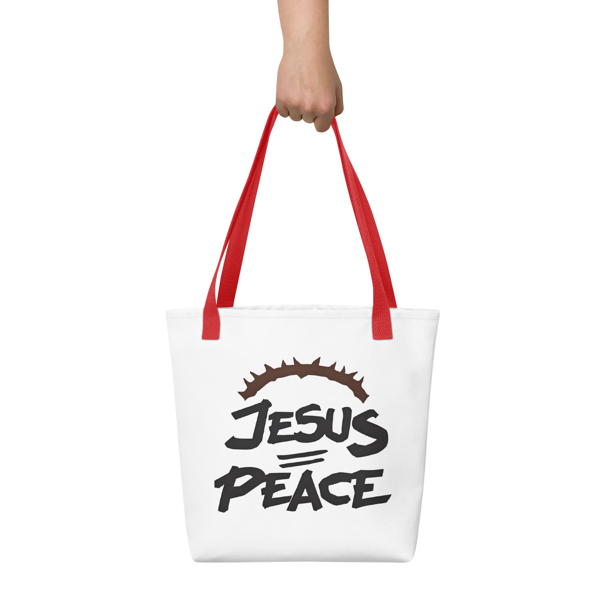 Tote bag carried by hand with red handles, showing the bold “JESUS PEACE” lettering and crown of thorns.