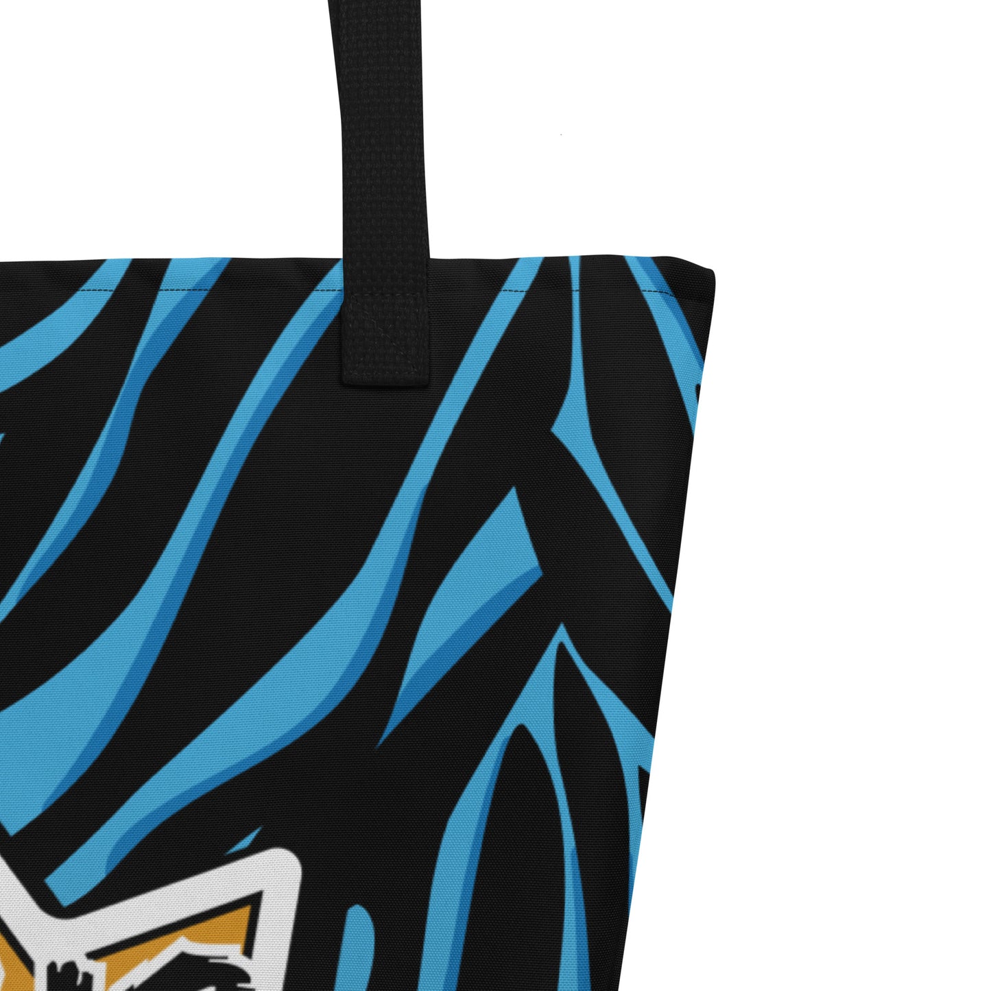 Close-up of the black woven handle, stitching along the top edge, and the black-and-blue patterned fabric.