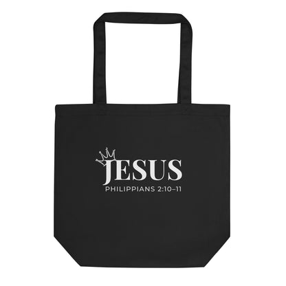 Black cotton tote bag with “JESUS” in white text, a small crown accent, and “Philippians 2:10–11” underneath.