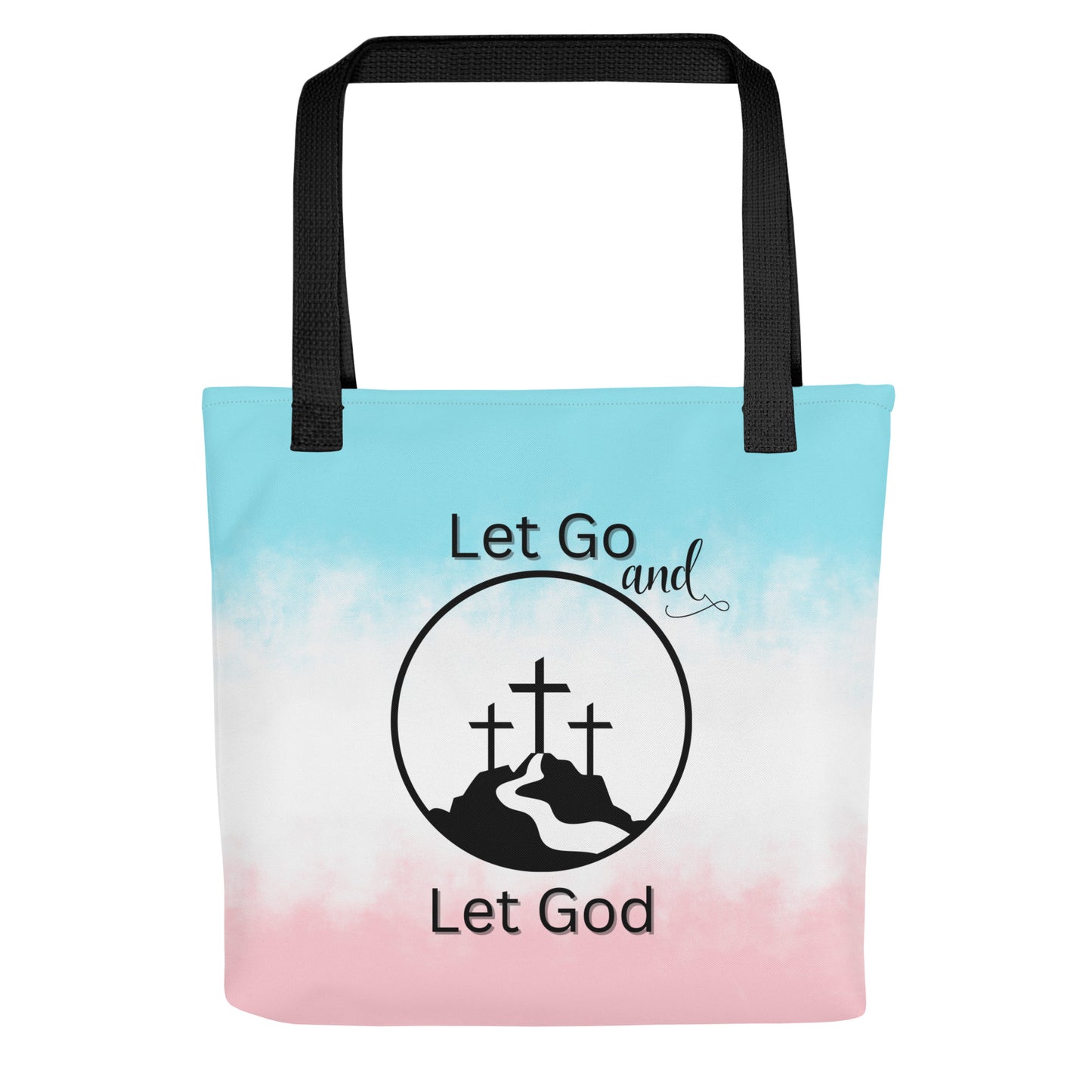 Front view of a tote bag with black handles, a blue-to-pink gradient background, and “Let Go and Let God” with a cross-and-mountain graphic.