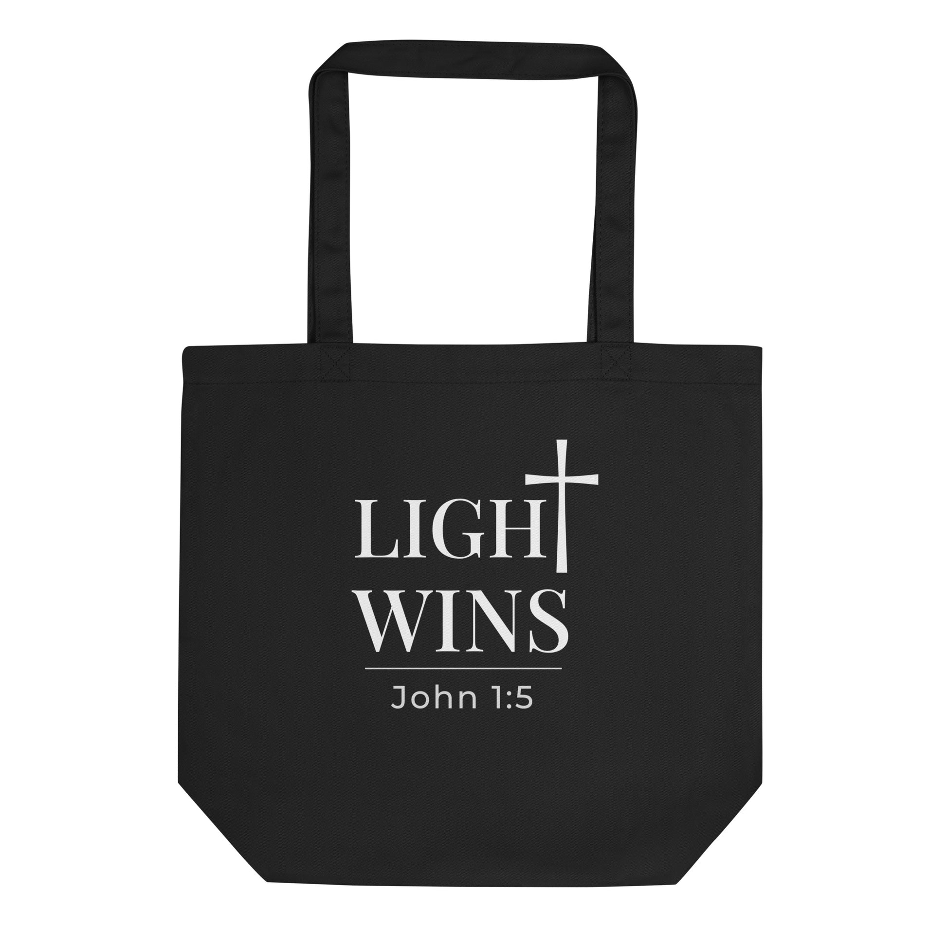 Front view of a black tote bag featuring “Light Wins,” a cross graphic, and “John 1:5” in white text.