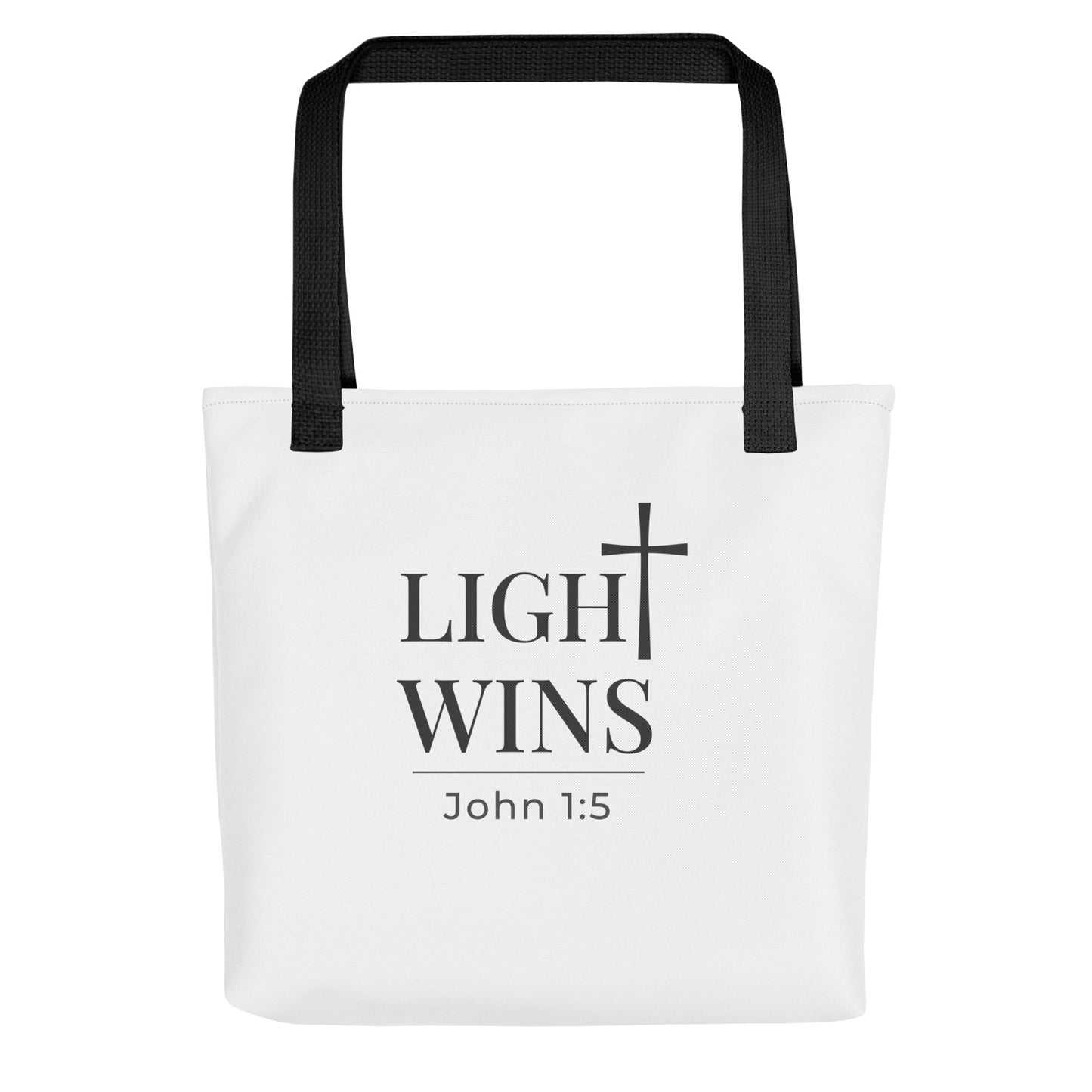 White tote bag with black handles featuring “Light Wins,” a cross graphic, and “John 1:5” in dark gray text.