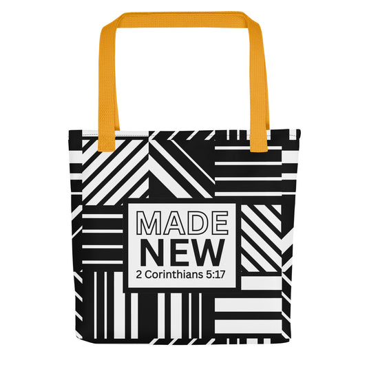 Front view of a tote bag with yellow handles and a black-and-white geometric stripe pattern, featuring a centered label that reads “MADE NEW” and “2 Corinthians 5:17.”