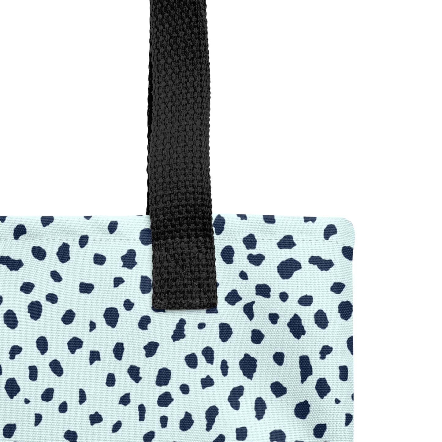 Close-up of black woven handle and stitched top edge on light blue fabric with navy speckle print.
