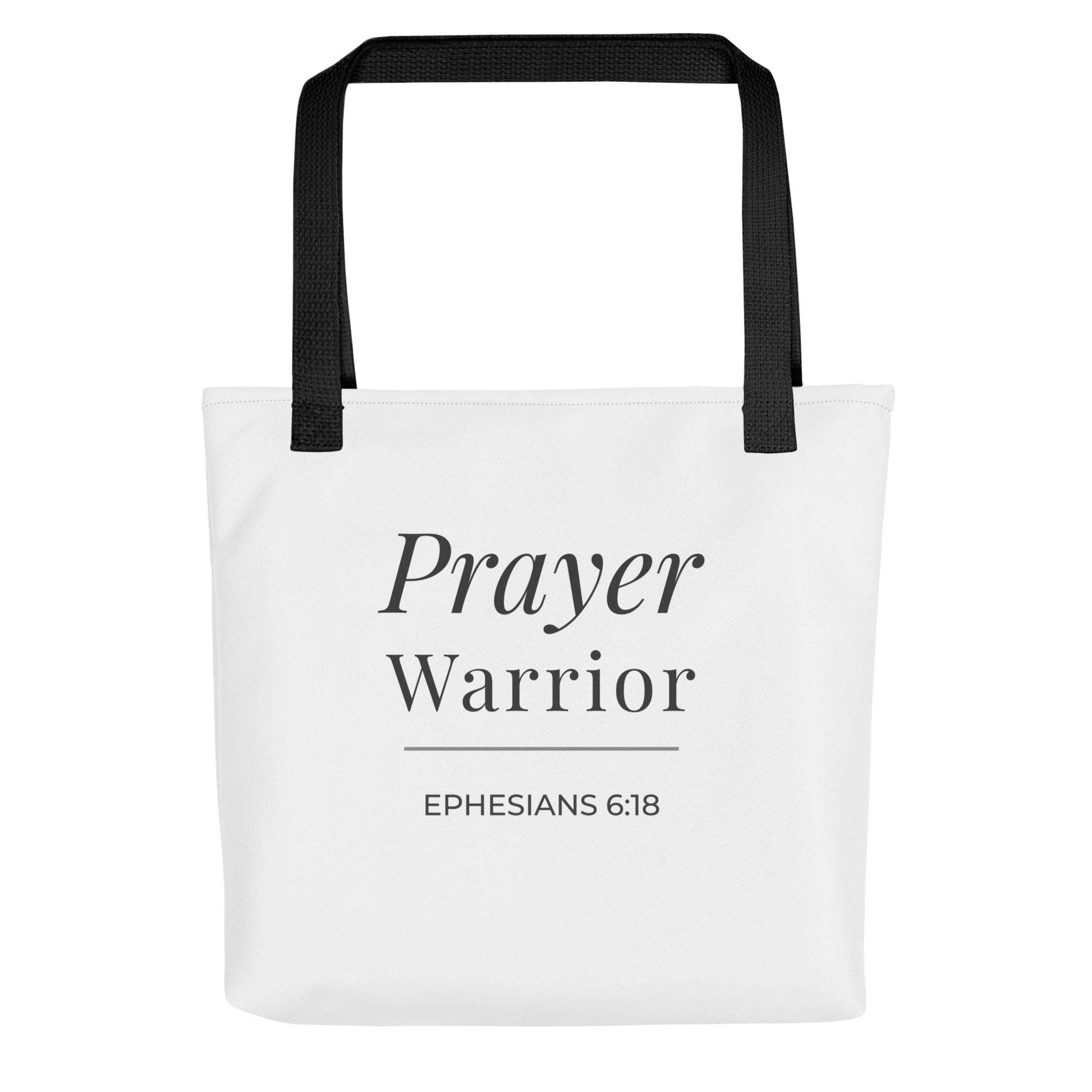 Front view of a white tote bag with black handles featuring “Prayer Warrior” and “Ephesians 6:18” in dark gray.